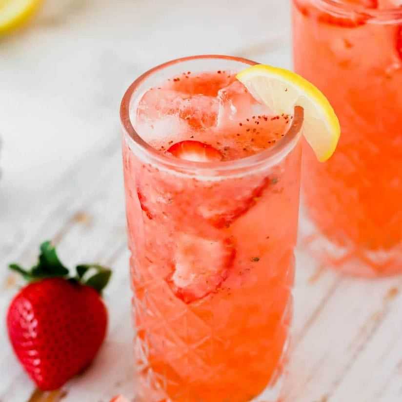 Refreshing strawberry lemonade with ice and a lemon slice in tall glasses.