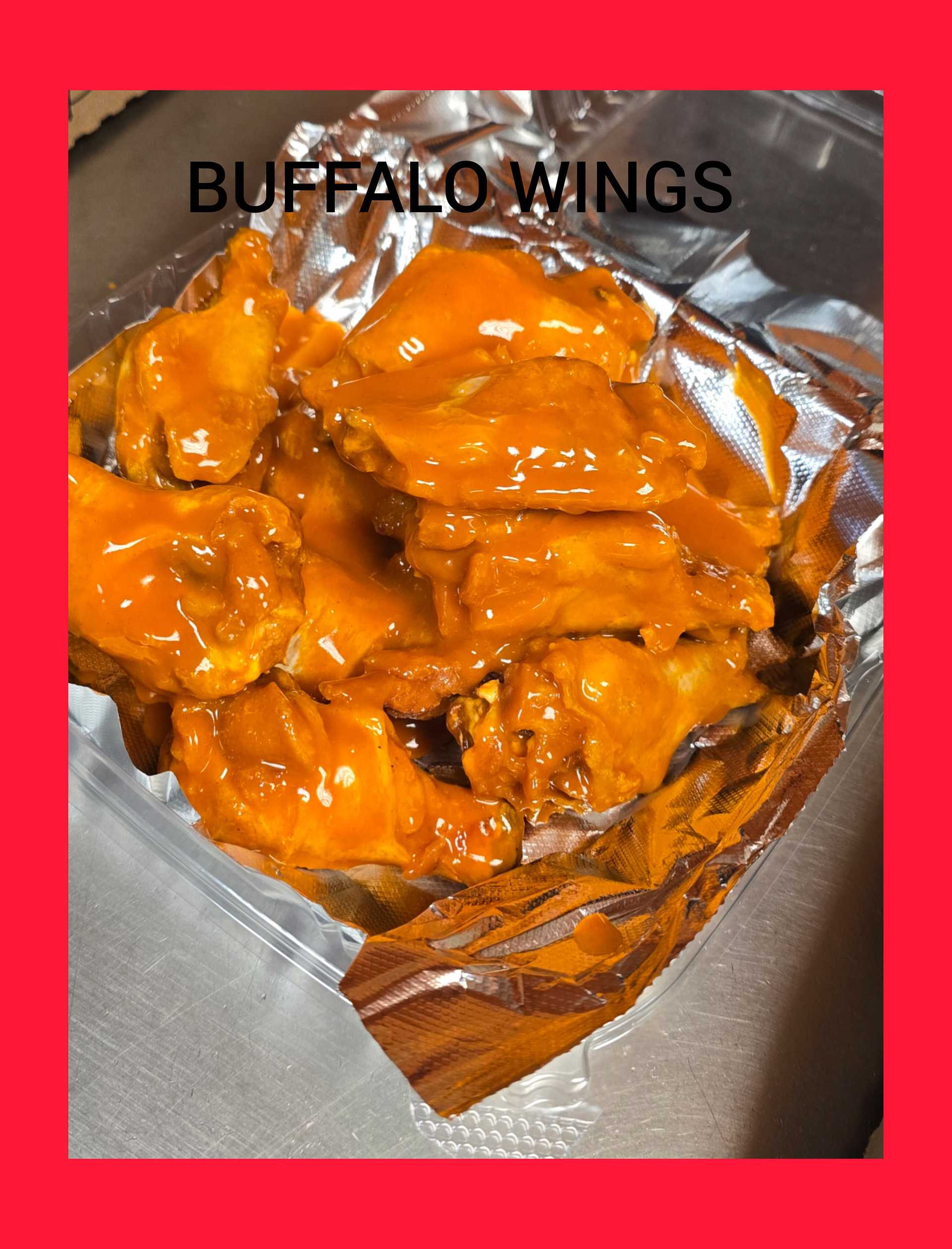 Buffalo wings coated in hot sauce served on a foil-lined tray.